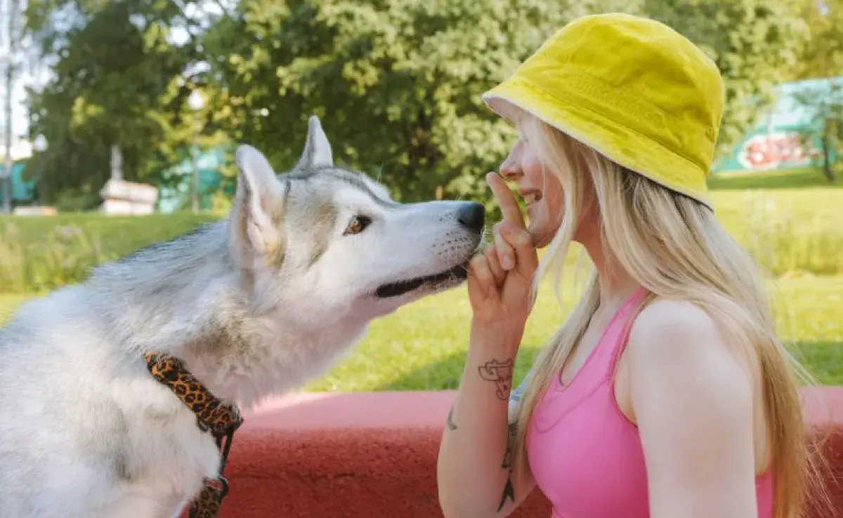 Husky con su dueña en el parque. Foto: Pexels/Yaroslav Shuraev