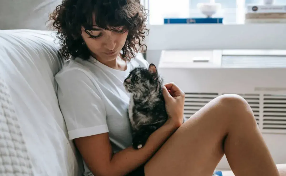 Mujer argentina acariciando a su gato. Foto: pexels/Sam Lion