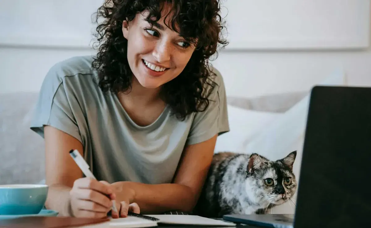 Mujer trabajando con su gato. Foto: Pexels/Sam Lion