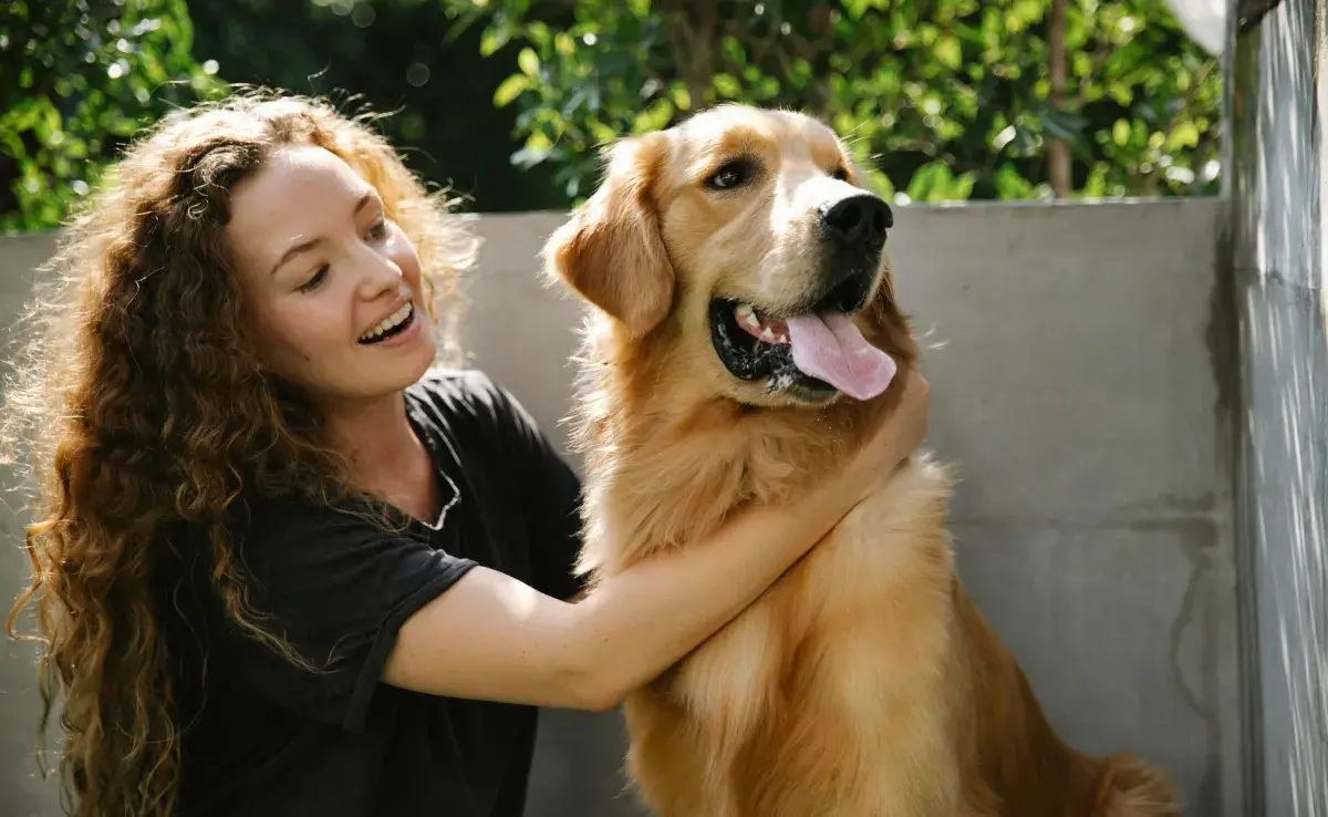 Mujer con un perro Golden. Foto: Pexels/Blue Bird