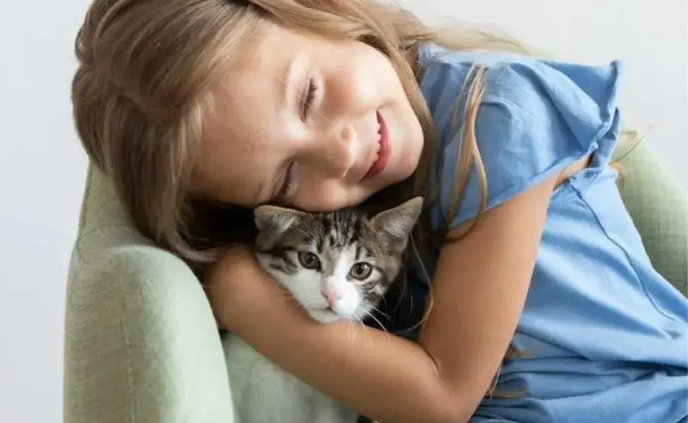 Niña abrazando un gato. Foto: Pexels/ KATRIN BOLOVTSOVA