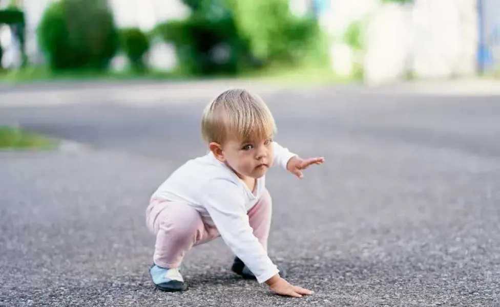 Niña tocando el piso de la calle. Foto: Envato/Nadtochii