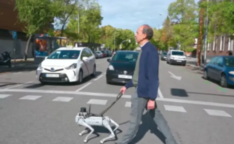 señor cruzando la calle con su perro guia robot. 