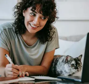Mujer trabajando con su gato. Foto: Pexels/Sam Lion