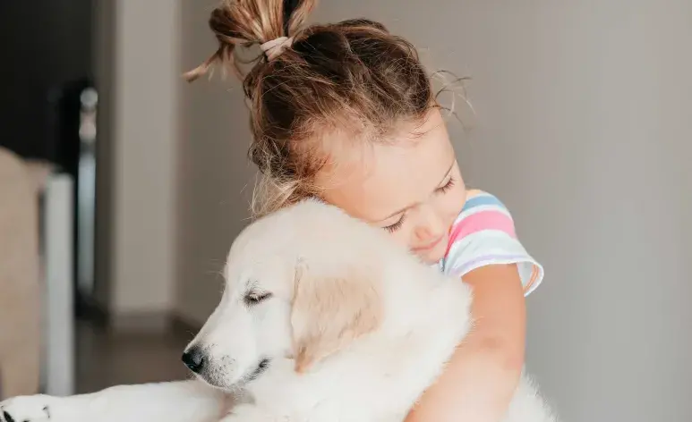 Niña con su perro de terapia el cual le ofrece beneficios como la mejora del estado de ánimo. Foto: Pexels/mawa_ts